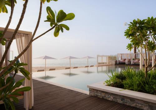 a view of the beach from the pool at a resort at Four Seasons Resort and Residences at The Pearl - Qatar in Doha