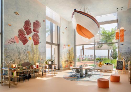 a childrens room with tables and chairs and a mural of butterflies at Four Seasons Resort and Residences at The Pearl - Qatar in Doha