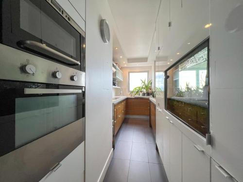 une cuisine avec un évier et une cuisinière dans l'établissement Full apt - Top floor - Eiffel Tower Panoramic View, à Issy-les-Moulineaux