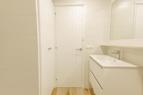 ein weißes Bad mit einem Waschbecken und einer Dusche in der Unterkunft Son Bou Gardens Deluxe 2 in Son Bou