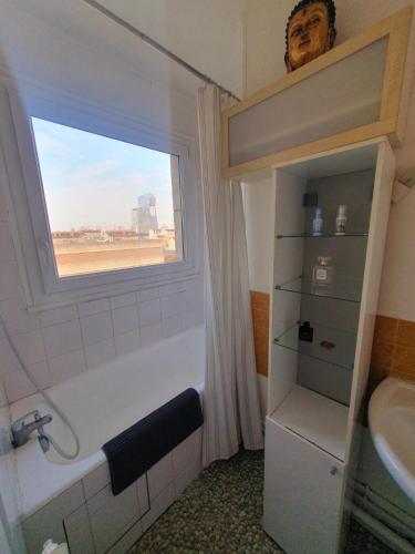 une salle de bain avec une baignoire, un lavabo et une fenêtre dans l'établissement Vue sur Paris, à Ivry-sur-Seine
