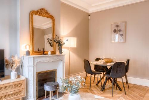 - un salon avec une table et un miroir dans l'établissement Le France - Les Jardins du Roi, à Fontainebleau
