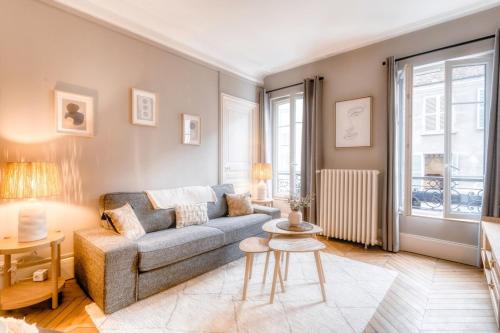 un salon avec un canapé et une table dans l'établissement Le France - Les Jardins du Roi, à Fontainebleau