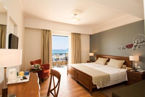 Mediterranean Beach Resort في لاغاناس: غرفه فندقيه بسرير وشرفه