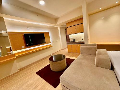 ARMERIA STAY DLF MY PAD في لاكناو: غرفة معيشة مع أريكة وتلفزيون بشاشة مسطحة