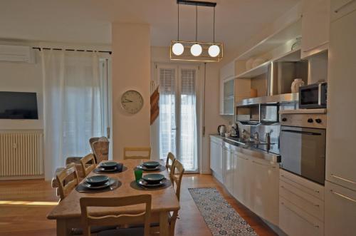 Una cocina con una mesa y sillas en una habitación. en la Bohème Peschiera luxury apartment, en Peschiera del Garda