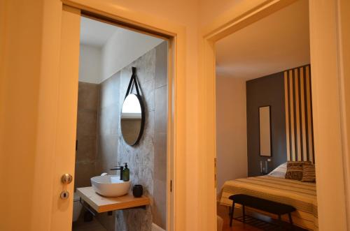 La salle de bains est pourvue d'un miroir, d'un lavabo et d'un lit. dans l'établissement la Bohème Peschiera luxury apartment, à Peschiera del Garda