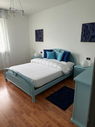 a bedroom with a large bed with blue pillows at Oma Margareta Apartment in Limone sul Garda