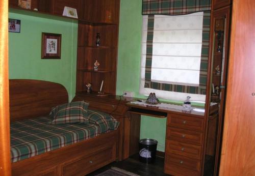 Habitación pequeña con cama y ventana en Finca El Carbayal, en El Campo