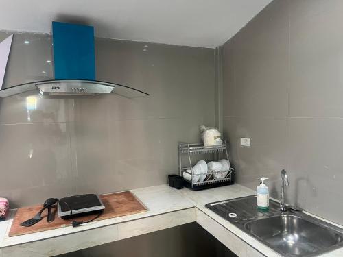a kitchen with a sink and a counter top at BeHome and Hostel in Chiang Mai