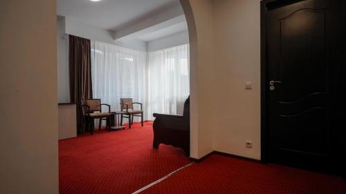 a room with a black door and a red carpet at Vila Trandafirul si Liliacul in Căciulata