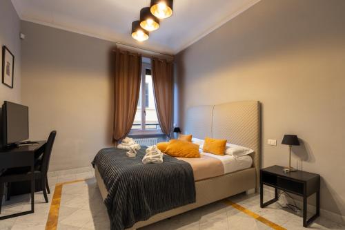 1 dormitorio con cama con almohadas de color naranja y escritorio en Compasso Suites, en Viterbo