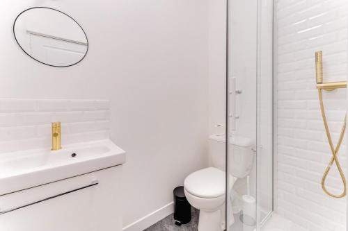 une salle de bain blanche avec des toilettes et un lavabo dans l'établissement La Ruche - Maison 7 chambres et 7 salles de bain, à Fontainebleau