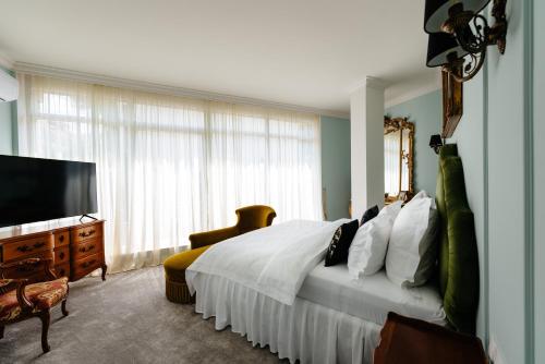 a bedroom with a bed and a flat screen tv at Ateneea Luxury Rooms in Cluj-Napoca