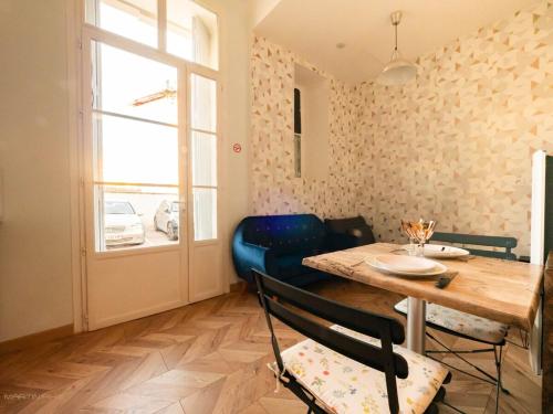 une salle à manger avec une table et des chaises et une fenêtre dans l'établissement Le Koukou - parking centre ville, à Montpellier