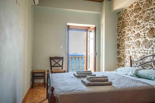 a bedroom with a bed with towels on it at Casa Del Mare Sea View House up to 6 guests in Mandrakion