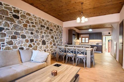 a living room with a couch and a stone wall at Casa Del Mare Sea View House up to 6 guests in Mandrakion