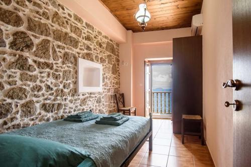 a bedroom with a stone wall and a bed at Casa Del Mare Sea View House up to 6 guests in Mandrakion