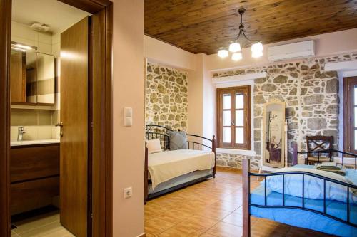 a bedroom with two beds in a room with a stone wall at Casa Del Mare Sea View House up to 6 guests in Mandrakion