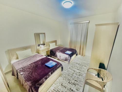 a bedroom with two beds and a mirror at Afnan Cairo Airport in Cairo