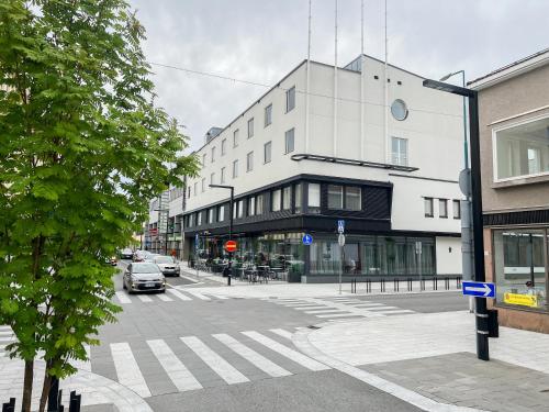 Original Sokos Hotel Valjus Kajaani في كاياني: شارع المدينة فيه مبنى وسيارة على الطريق