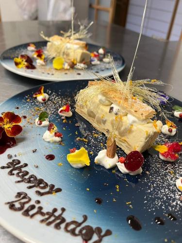 two plates of food on a table with a birthday cake at 村の小さなお宿　おきな in Tosa