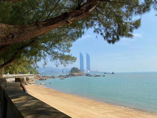 a beach with a view of the ocean and a tree at City Hotel Xiamen-Free Welcome Fruits in Xiamen