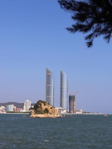 an island in the water with buildings in the background at City Hotel Xiamen-Free Welcome Fruits in Xiamen
