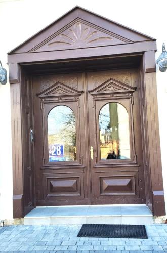 a large wooden door with a sign on it at APARTAMENT JARACZA 28/9 in Słupsk