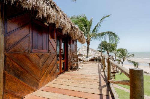a wooden walkway leading to a resort with palm trees at Villa Mango in Icaraí