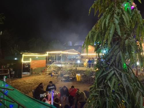 un grupo de personas de pie alrededor de un mercado por la noche en Marine Drive Retreat, en Rishīkesh