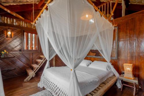 a bedroom with a bed with a mosquito net at Villa Mango in Icaraí