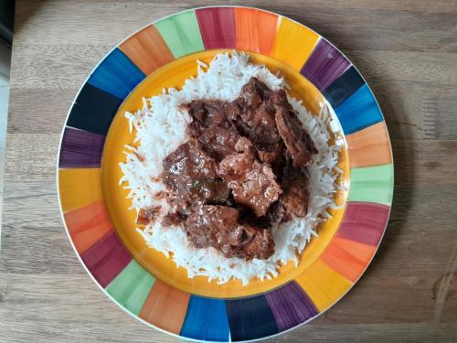 a plate of rice and meat on a colorful plate at Lakaz Metiss Arobaz in Blue Bay