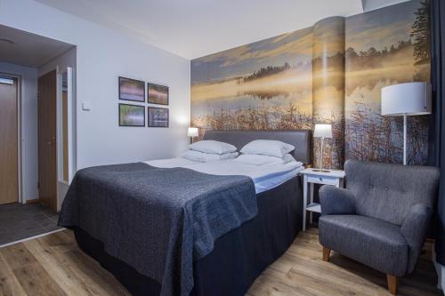 a bedroom with a bed and a chair at Original Sokos Hotel Valjus Kajaani in Kajaani