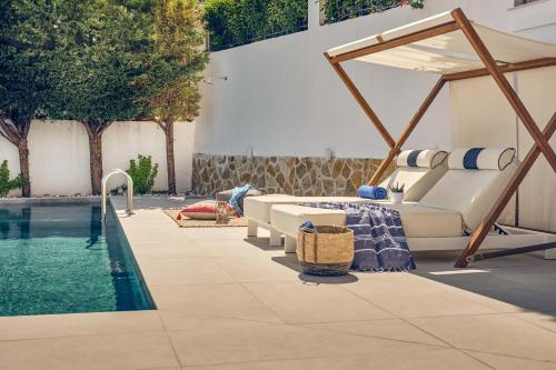 a pool with a bed and a canopy next to a swimming pool at Ether Villa View in Lithakia