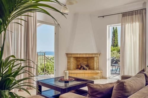 a living room with a couch and a fireplace at Ether Villa View in Lithakia