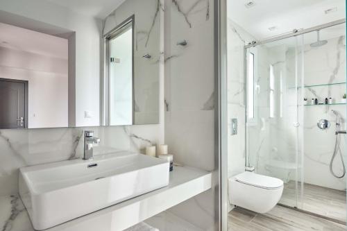a white bathroom with a sink and a toilet at Ether Villa View in Lithakia