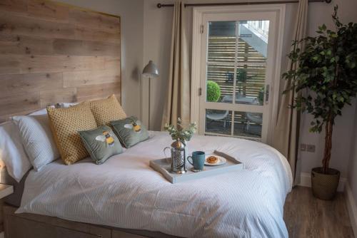 a bedroom with a white bed with a table on it at Stunning City Apartment in the Heart of Plymouth in Plymouth