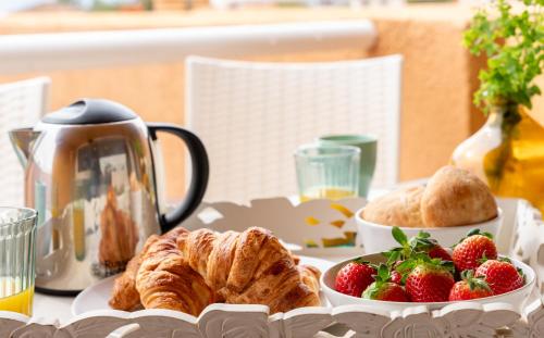 a table with a plate of croissants and strawberries at Apartamento Dos Mares by Rental Olé in La Manga del Mar Menor