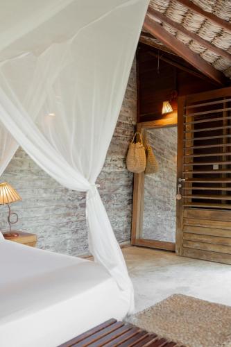 a bedroom with a bed with a white curtain at Villa Mango in Icaraí