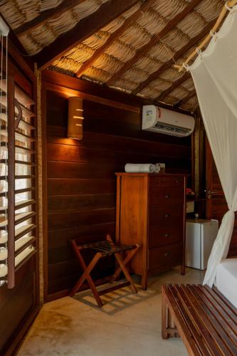 a room with a bed and a dresser and a bench at Villa Mango in Icaraí