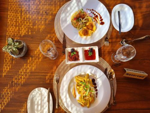 dois pratos de comida numa mesa de madeira em Manthra Leisure em Kandy