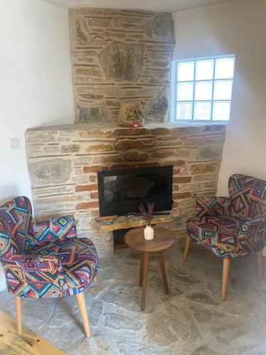 een woonkamer met 2 stoelen en een open haard bij Selanik Pansiyon in Selcuk