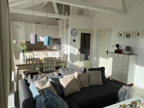 a living room with a couch and a kitchen at Boerenslag 41 in Sint Maartensvlotbrug