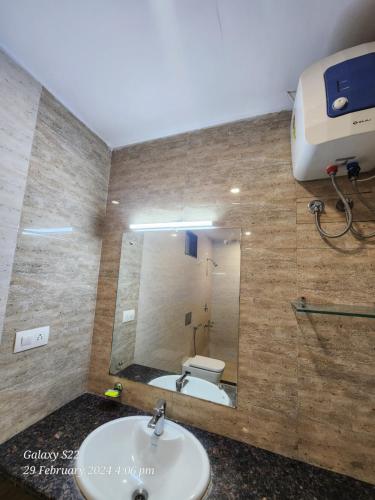 a bathroom with a sink and a toilet and a mirror at Rani Palace Hotel And Resort in Kishangarh