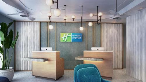 a lobby with two desks and a green chair at Holiday Inn Express Bali Sunset Road, an IHG Hotel in Legian