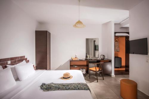 a bedroom with a bed with a hat on it at Sunlight Elounda - Adults only Hotel "by Checkin" in Agios Nikolaos