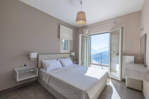 a bedroom with a bed and a large window at Villa Olive Grove Kefalonia in Ferendináta
