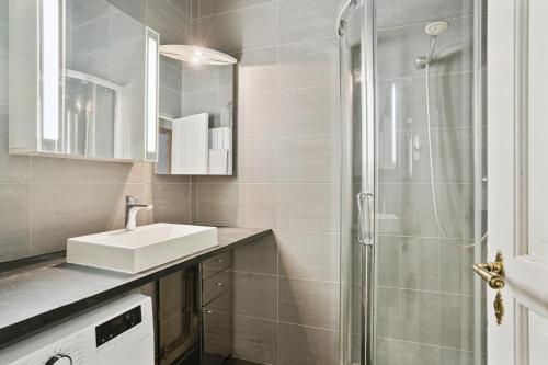 y baño con lavabo y ducha. en Appartement au coeur du Marais à Paris by Weekome en París