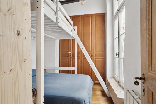 a bedroom with a bunk bed and a ladder at Appartement au coeur du Marais à Paris by Weekome in Paris